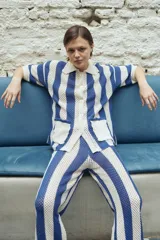 Pantalón de punto calado a rayas verticales azules y blancas, con cintura elástica.
