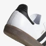 Championes Adidas Samba OG blancos con tres tiras negras a los costados y suela marrón de goma.