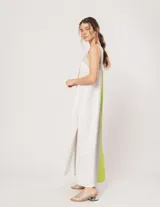 Vestido largo de lino color blanco, gris y amarillo, con breteles anchos, escote recto, elástico en la espalda y tajos laterales.