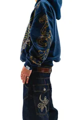 Hoodie azul con cierre y bolsillos laterales, con estampado dorado de hojas de acanto en el frente y las mangas.