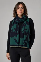 Bufanda rectangular de tejido suave con diseño estampado de manchas abstractas en tonos verde oscuro y negro, con terminaciones desflecadas en los extremos.