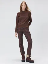 Polera de manga larga confeccionada en tela rib color bordó, con cuello alto y hombreras. Presenta costuras a la vista con pespuntes en hilo de color contrastante en el cuello, puños, hombros y ruedo.