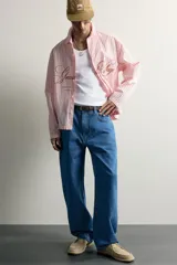 Jeans loose fit de tiro medio, confeccionados en denim de algodón color azul con efecto lavado. Presentan diseño de cinco bolsillos, bolsillo plastrón estilo carpintero en la pierna y cierre frontal con cremallera y botón.