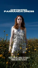 Vestido corto plateado, estilo halter, confeccionado con piezas cuadradas de material metálico o efecto metalizado unidas entre sí.