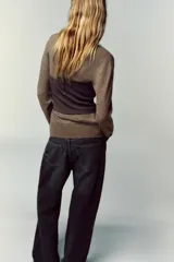 Top bustier corsetero color gris oscuro, con escote recto, solapa y hombros descubiertos. Presenta falsos botones forrados a tono en el frente y cierre lateral con cremallera oculta.