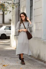 Vestido midi de tejido de punto color gris, con cuello a la base, mangas tres cuartos tipo oxford y detalle de calado geométrico en las mangas y en el ruedo.