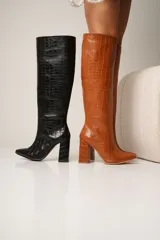 Botas altas de cuero vegano con estampado de cocodrilo, taco cuadrado y punta fina. Disponibles en color negro y marrón. La caña mide 40cm y el taco 8cm.