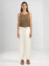 Pantalón estilo cargo color blanco, confeccionado en lino tencel, con bolsillos laterales y elástico en la cintura.