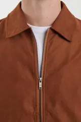 Campera de napa ecológica color marrón, con cierre frontal metálico, bolsillos laterales y cuello camisero.
