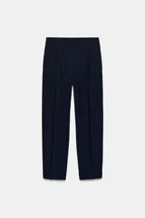 Pantalón de tiro alto con pinzas frontales, diseño de raya diplomática, bolsillos laterales y bajo con vuelta.