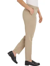 Pantalón chino color beige de sarga elástica, corte slim, con cierre de cremallera y botón, bolsillos traseros de ojal y logo de Tommy Hilfiger bordado en la parte trasera.