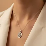 Conjunto de cadena y dije ovalado con la imagen de San Gabriel, confeccionado en plata 925 con acabado envejecido.