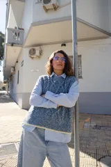 Chaleco tejido de punto con diseño de ochos, cuello redondo y sisa profunda. Presenta un detalle de terminación en color contrastante en el ruedo.