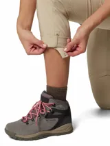 Pantalón convertible Columbia de senderismo color beige, con perneras desmontables mediante cremallera que permiten transformarlo en shorts. Cuenta con bolsillos laterales y traseros, y tecnología de protección solar.