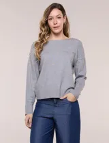 Buzo de punto fino color gris, de calce relajado, escote redondo amplio y canesú con textura acanalada. Cuenta con apliques de tachas metálicas doradas en la línea del hombro, mangas largas de hombro caído y puños y ruedo acanalados.