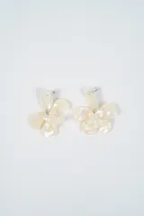 Aros colgantes con diseño de flor en material acrílico con efecto nacarado.