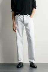 Jeans regular fit de corte recto y tiro medio, confeccionados en denim de algodón blanco con diseño de cinco bolsillos y cierre frontal con cremallera y botón.