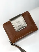 Billetera compacta de cuero texturizado color marrón, con solapa frontal en cuero metalizado dorado que presenta un grabado de búho. Incluye cierre lateral y correa de muñeca a juego.