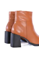 Botines de cuero vacuno liso color caramelo, con caña media, cierre lateral y puntera cuadrada. Presentan un tacón bloque de color negro.