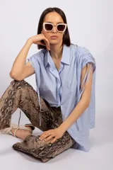 Camisa sin mangas color verde esmeralda, con cuello clásico, cierre frontal con botones y tiras regulables en los hombros.