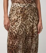 Pantalón ancho de tule con estampado de leopardo, cintura y puños elásticos. El conjunto se compone de un top sin mangas con cuello alto y un pantalón a juego con fajín anudado a la cintura.