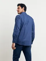 Camisa celeste de manga larga con cuello button-down, confeccionada en tejido rústico de algodón y lino.