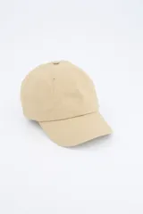 Gorra de béisbol color beige con visera curva, ojales bordados para ventilación y ajuste trasero metálico.