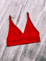 Top triángulo de breteles finos, confeccionado en tejido de punto elástico. Disponible en varios colores: rojo, negro, mostaza, beige, verde, ladrillo, fucsia, azul y blanco.