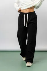 Pantalón de corte relajado y pierna recta, confeccionado en tejido tipo corderoy liviano. Presenta cintura elastizada con cordón ajustable y diseño de silueta amplia.