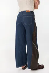 Jean de pierna ancha color azul con detalles en los laterales con estampado animal print marrón, de tiro alto y bolsillos plaqué en la espalda, marca Petra.