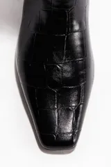 Botas altas de mujer, color negro, con textura de cocodrilo en charol. Presentan puntera cincelada y taco cuadrado forrado.