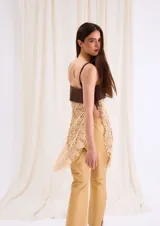 Top largo con cuerpo de cuero marrón chocolate y diseño inferior de crochet en tono beige, con tirantes finos y flecos laterales.