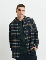 Sobrecamisa de manga larga con diseño a cuadros, cuello camisero y bolsillo frontal. Confeccionada en tejido de poliéster y algodón, sin forro.