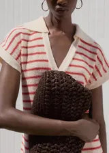 Vestido midi de punto fino con diseño a rayas horizontales en color crema y rojo. Presenta un corte recto, cuello camisero con escote en pico y mangas cortas.