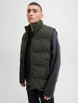 Chaleco acolchado de diseño puffer con cuello alto y cierre frontal con cremallera. Presenta un acabado liso y minimalista, ideal para capas de abrigo.