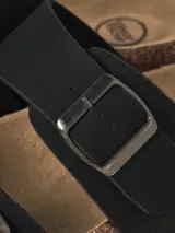 Sandalias estilo Birkenstock color negro con dos tiras ajustables con hebillas metálicas, plantilla anatómica con reborde de corcho y suela de goma.