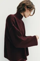 Jersey de punto color bordó con cuello subido, manga larga y diseño de corte holgado con costuras caídas en los hombros.
