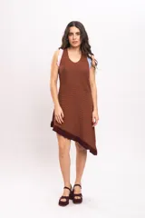 Vestido corto de tejido de punto color marrón, sin mangas, con diseño asimétrico en el ruedo terminado con flecos y detalles de ribetes en tonos rosado y celeste en los hombros.