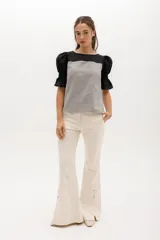 Blusa de corte relajado con cuerpo a rayas horizontales y mangas cortas abullonadas de color sólido. Presenta escote redondeado y puños con elástico.