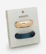 Kit de dos brazaletes, uno rígido de resina en color azul traslúcido con forma orgánica y otro de metal liso en tono dorado con diseño redondeado.