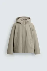 Parka de hombre confeccionada en tejido técnico con acabado efecto engomado, cuello subido con capucha ajustable, cierre frontal con cremallera oculta por solapa con botones a presión, bolsillos de vivo en la cadera y puños ajustables.