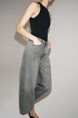 Jeans de tiro medio con corte relajado y largo al tobillo. Presenta diseño de cinco bolsillos, trabillas en la cintura y cierre frontal con cremallera y botón metálico.
