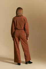 Pantalón de corte ancho y silueta relajada, confeccionado en tejido de efecto gamuzado color marrón oscuro. Presenta un diseño de tiro alto con cierre frontal y bolsillos laterales.