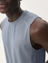 Musculosa deportiva de color gris, confeccionada en tejido técnico transpirable con textura microperforada, ideal para entrenamiento.