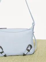 Mini cartera bandolera de cuero vacuno flor color negro con interior al tono. La correa regulable combina cuero y pelo, y lleva hebillas metálicas personalizadas.