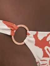 Conjunto de bikini con estampado floral color naranja y blanco, con corpiño con aro central y bombacha con aro lateral.