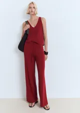 Pantalón de punto fino color bordó, de diseño recto y largo, con cintura elástica y cordón ajustable.