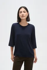 Remera de viscosa en color verde oliva, con cuello redondo y mangas 3/4. Presenta un diseño de tejido acanalado y corte holgado.