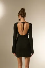 Vestido corto negro de tejido acanalado, manga larga y escote barco.