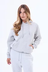 Buzo tipo canguro de felpa color marrón, con capucha ajustable mediante cordones y bolsillo frontal tipo canguro.